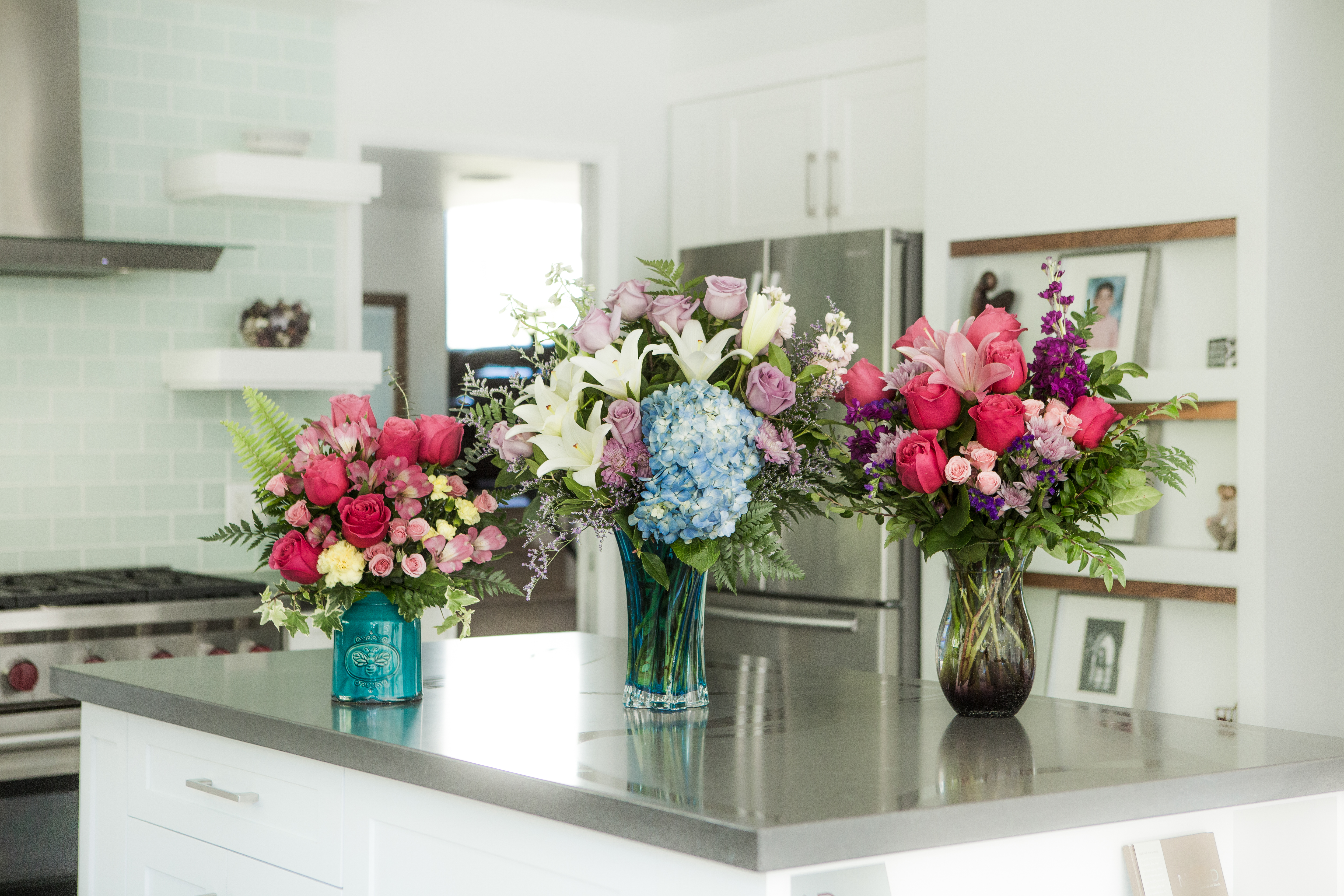 flowers in vibrant vases on the kitchen counter