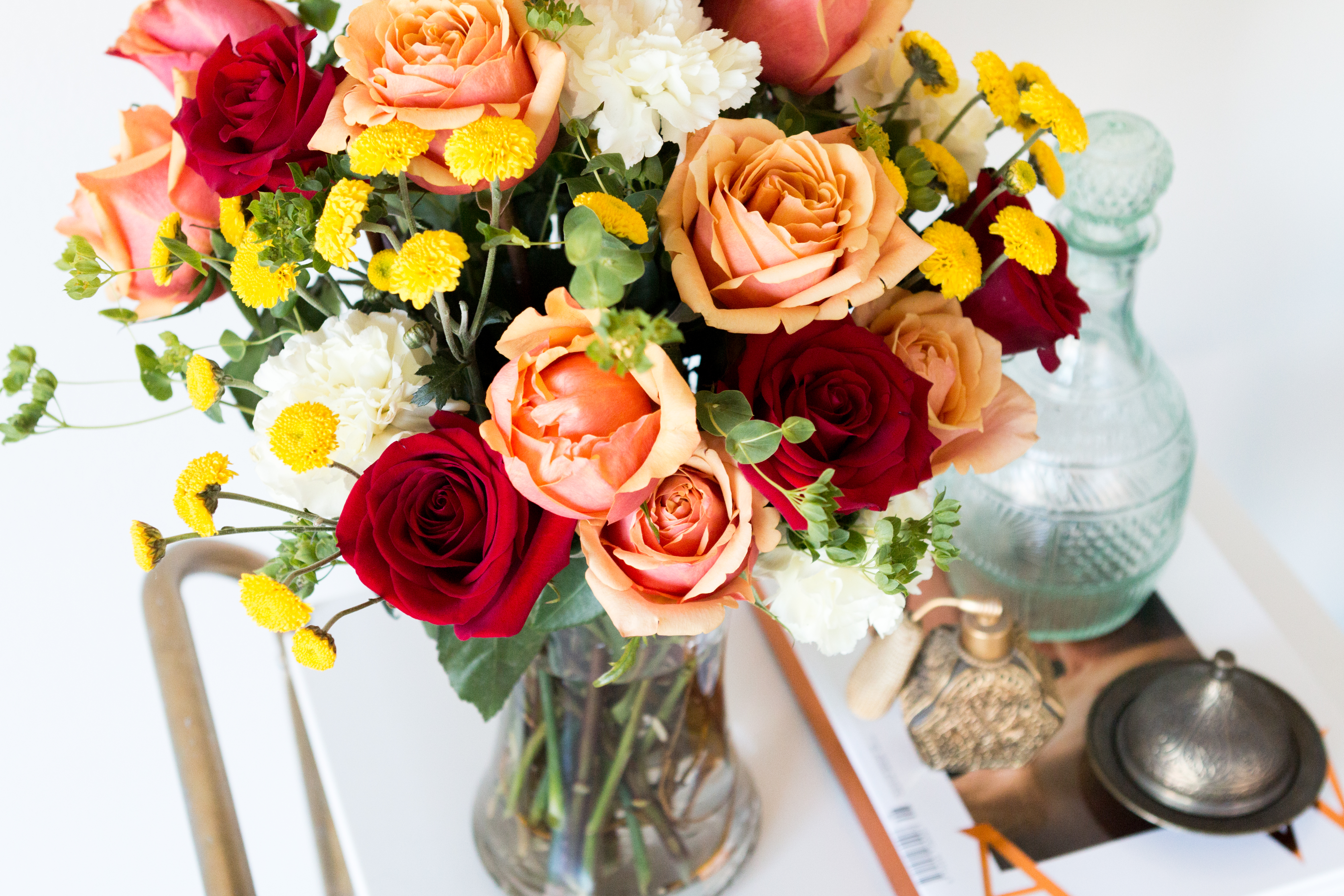 orange and red roses with yellow and white flowers