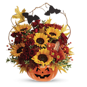 yellow sunflowers, red mums, and more fill a ceramic pumpkin with bats flying above