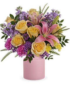 Bright roses and lilies fill a pink vase