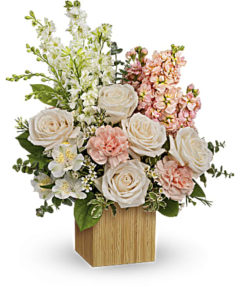 Peach and white flowers fill a bamboo container