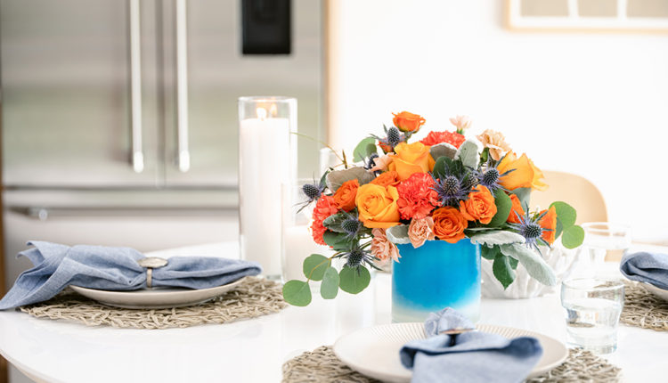 Orange flowers fill a vibrant blue vase